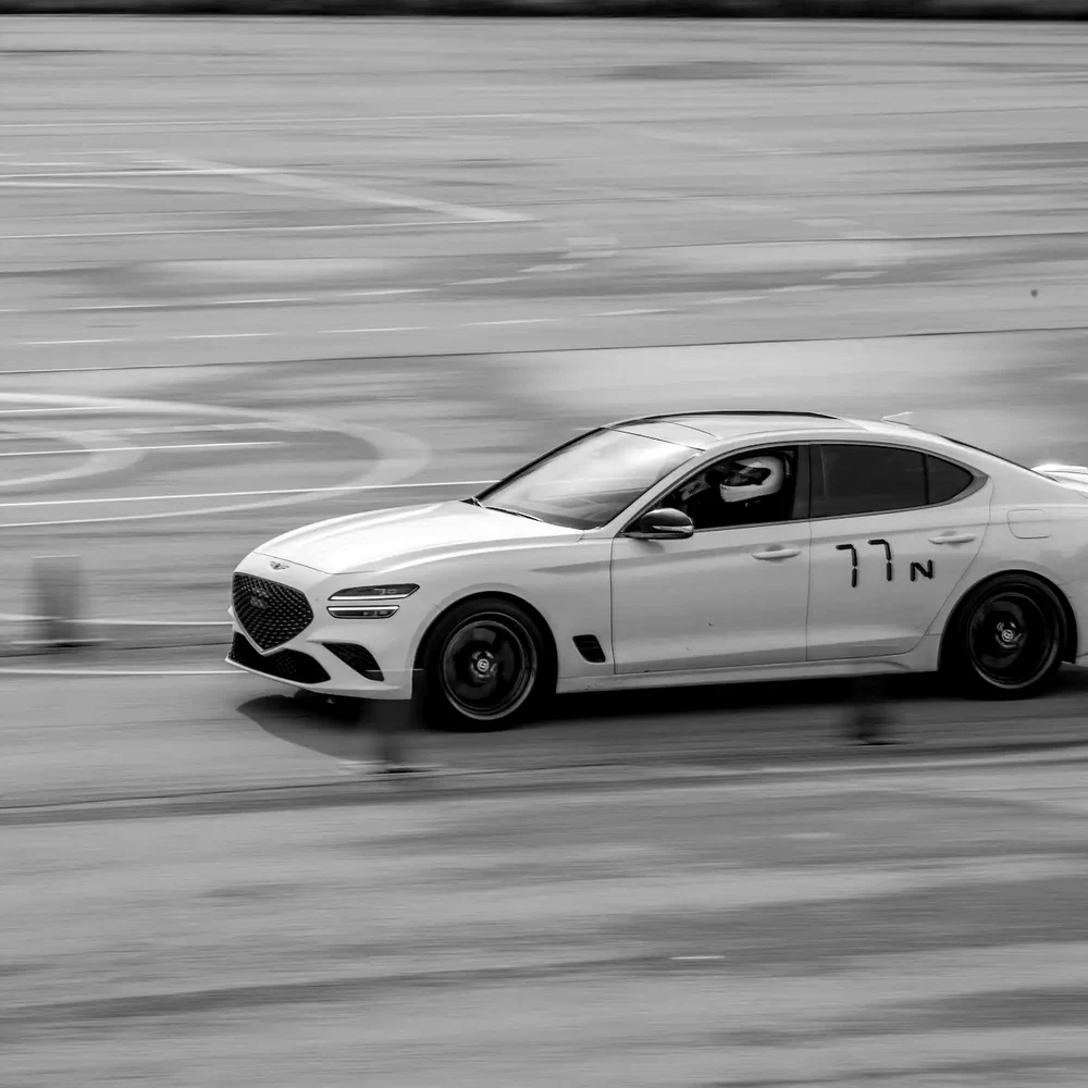 Driving a white Genesis G70 through an autocross corner